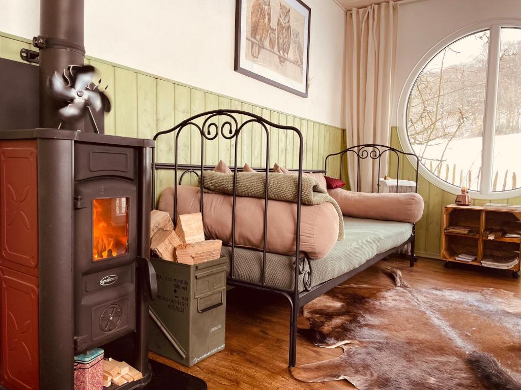 索恩堡Eulennest - Tiny House im Habichtswald的一间卧室配有一张床和一个燃木炉子