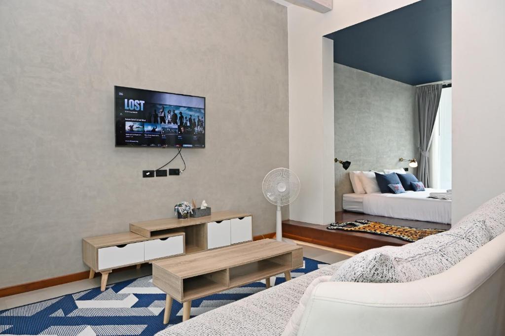南府Villa Mahaphrom的客厅配有沙发和墙上的电视