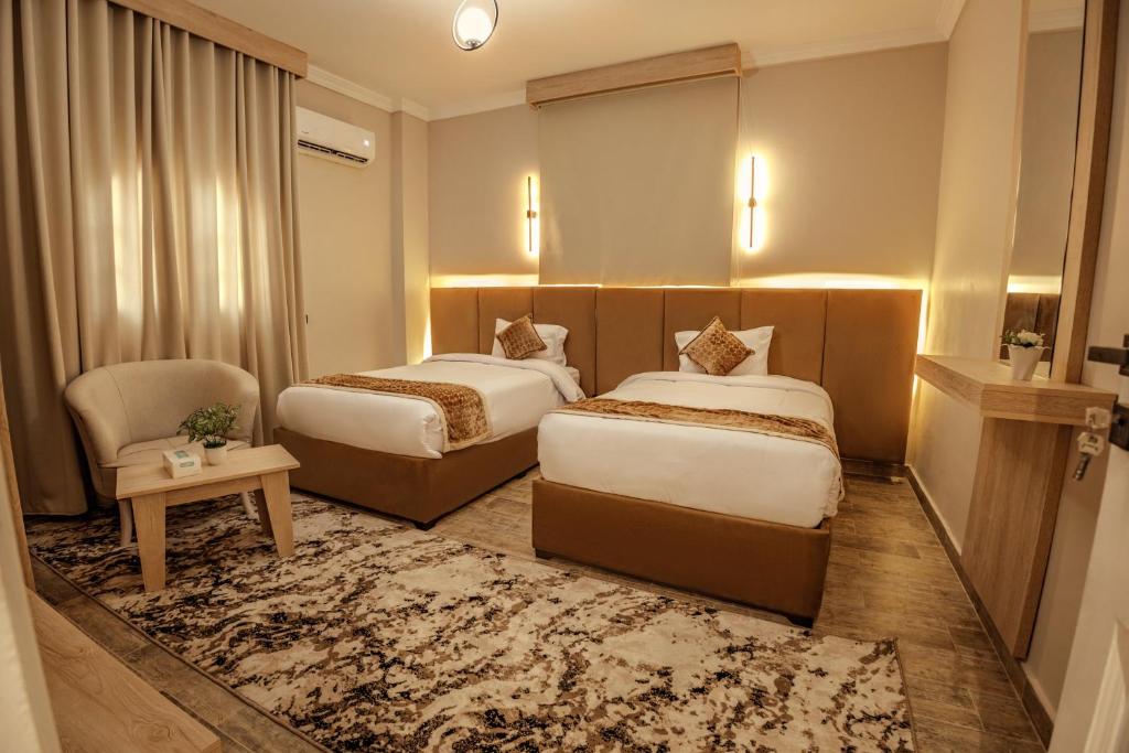开罗Golden House的酒店客房,配有两张床和椅子