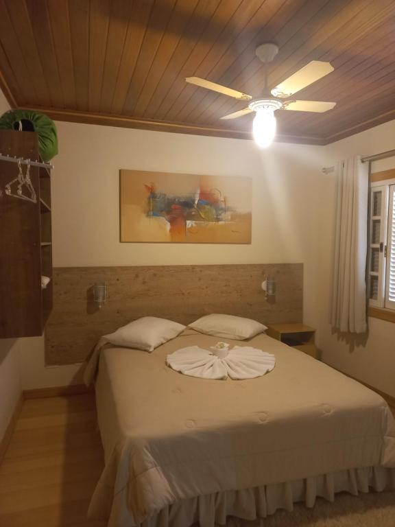 帕萨夸特鲁Pousada Eco Da Montanha的一间卧室配有一张带吊扇的床