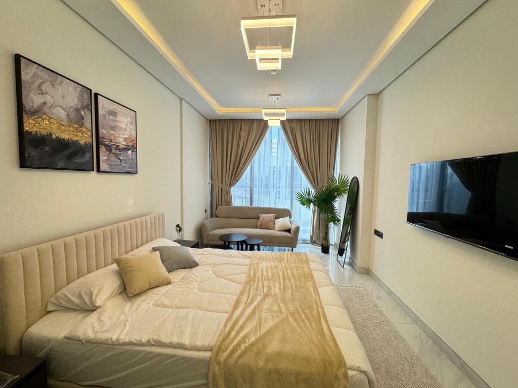 迪拜Furnished studio استديو مفروش studio city的酒店客房,配有床和电视