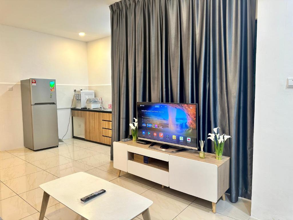 宾南邦ITCC Manhattan Suites by AURORA的一间客厅,配有一张桌子上放的电视