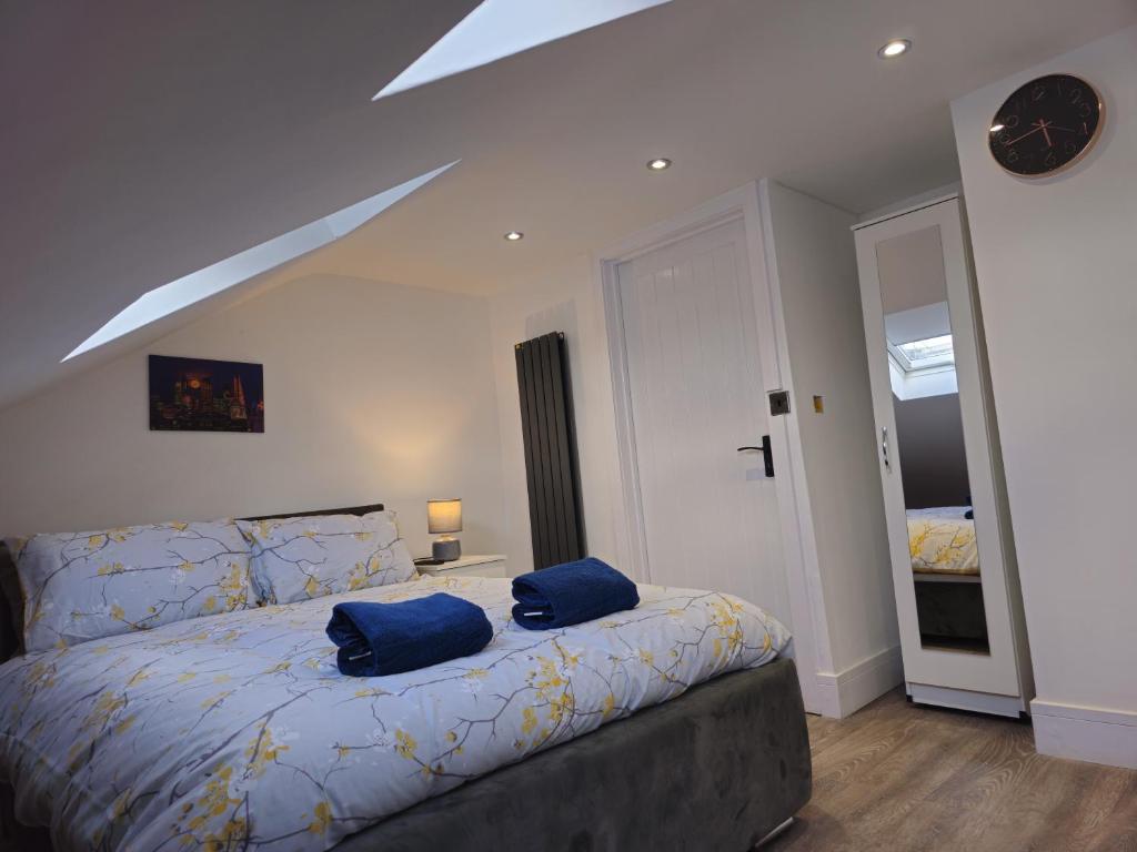 伦敦Forest Edge Inn的一间卧室配有一张带两个蓝色枕头的床