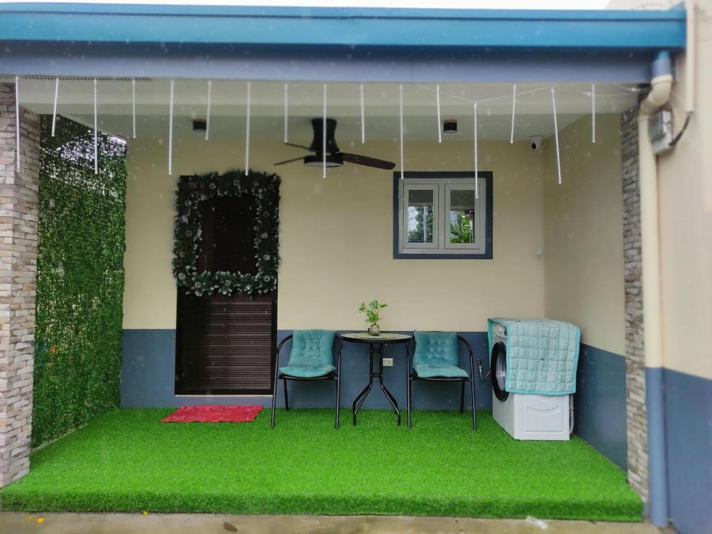 LocsinCasita de Reina Staycation House - A cozy 1-Bedroom condo-style house的一个带绿草和桌椅的庭院