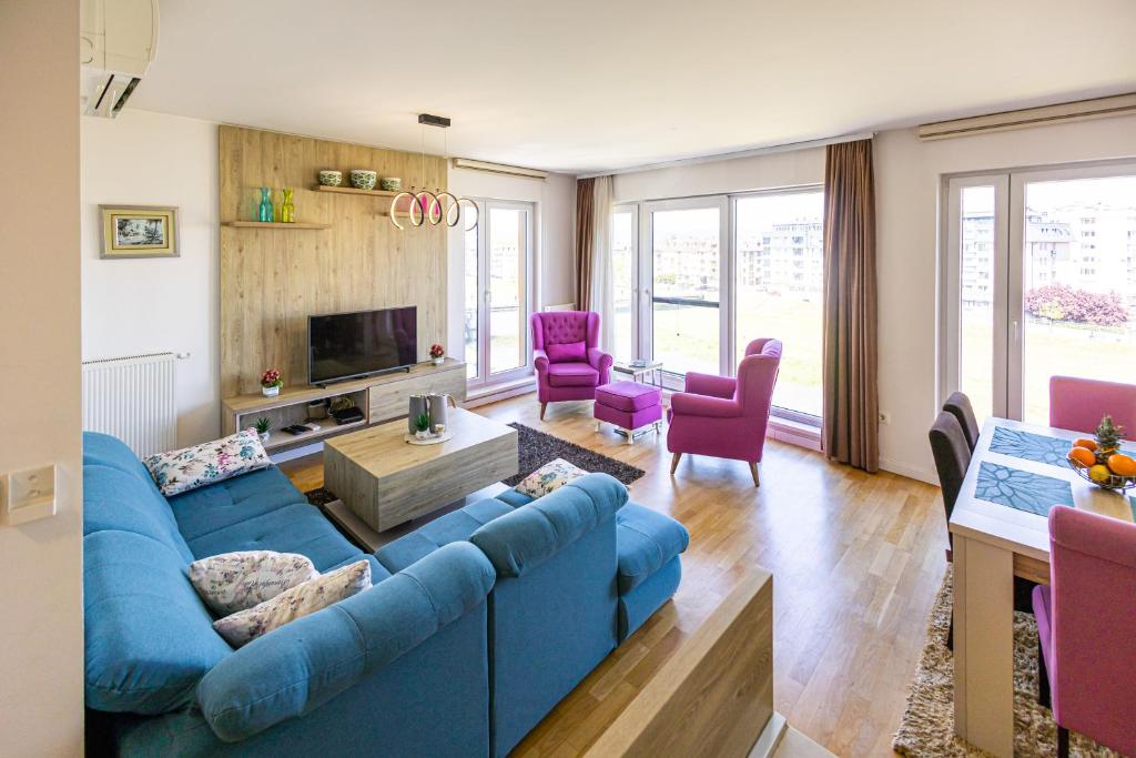 萨拉热窝Ilidza River Apartments的客厅配有蓝色的沙发和紫色的椅子