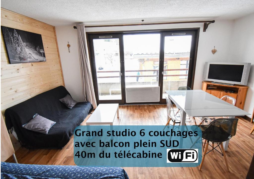 圣让多尔普Le Relai S34 - Grand et lumineux studio avec coin montagne 4-6 pers avec WIFI, 50m des pistes, grand balcon exposé SUD, DRAPS NON COMPRIS的客厅配有沙发和桌子