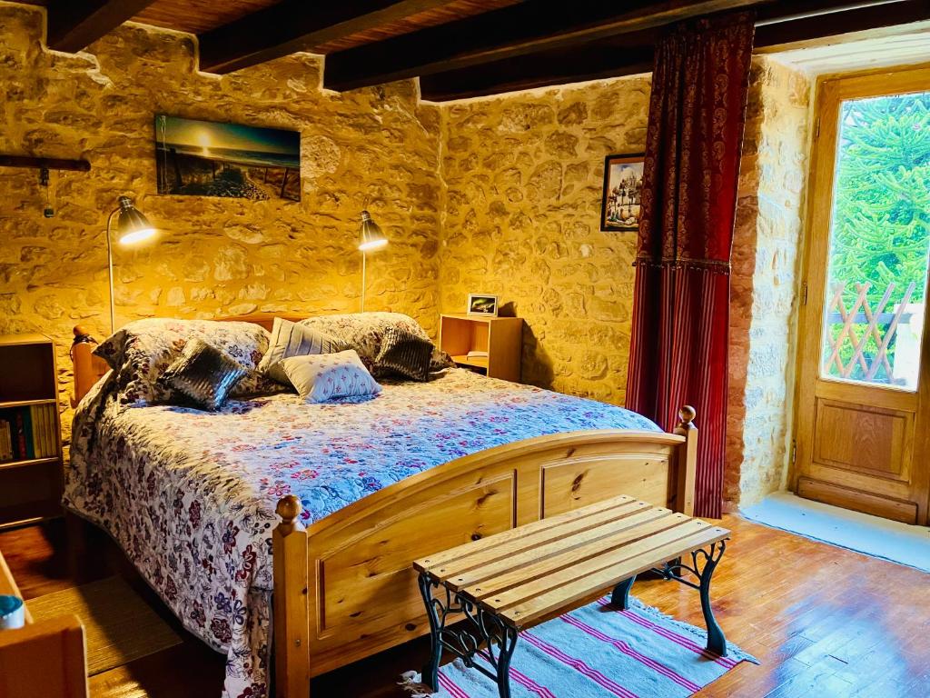 维特拉克Maison de Montfort的一间卧室配有一张床和一张木凳