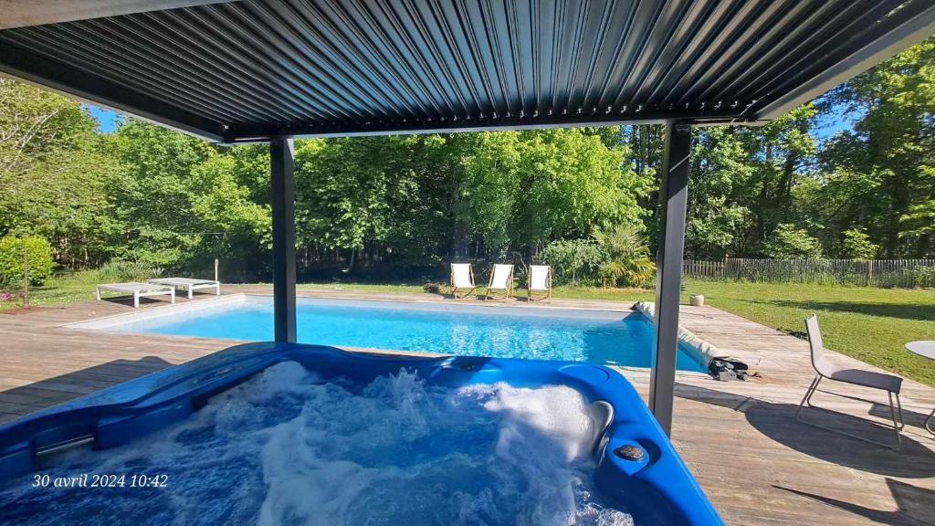 萨莱Domaine de Cachaou Logis du Pujeau sauna & spa piscine chauffée的游泳池旁的蓝色热水浴池