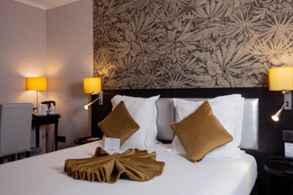 巴黎贝斯维斯特阿尔格鲁内申酒店的酒店客房配有带白色床单和枕头的床。