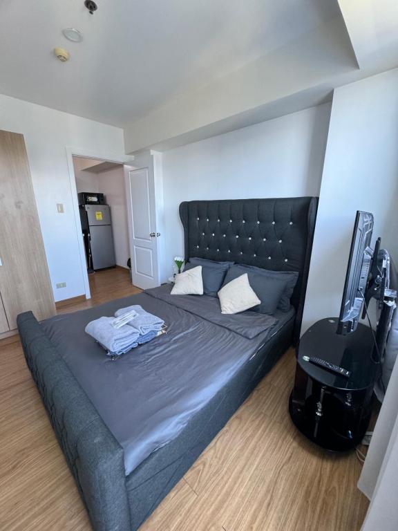马尼拉Bias Haven Azure Urban Resort Residences的一间卧室配有一张床,电视