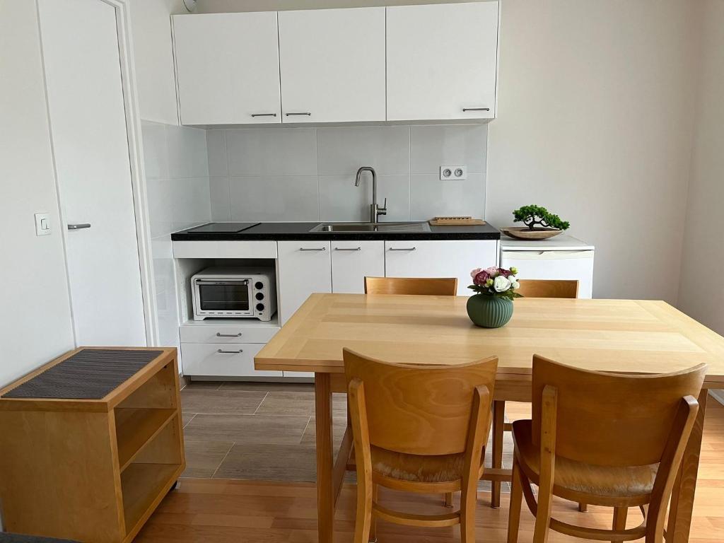 马尔利港Studio rénové avril 2024 wifi et parking的厨房配有木桌和白色橱柜。