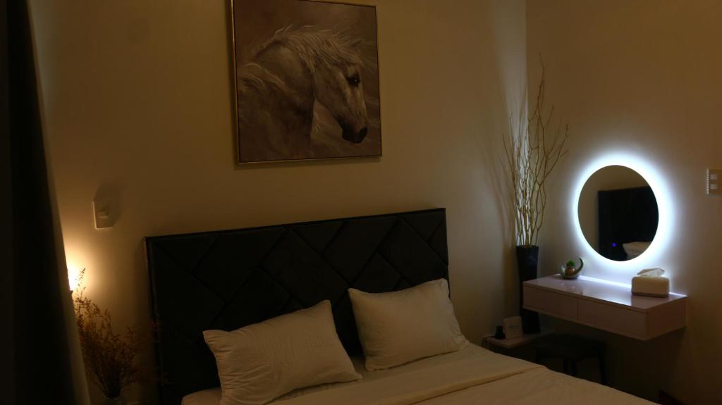 达沃市Triann Condo Staycation Davao in Inspiria Condominium Building的卧室配有一张床铺,墙上挂着一幅马的照片