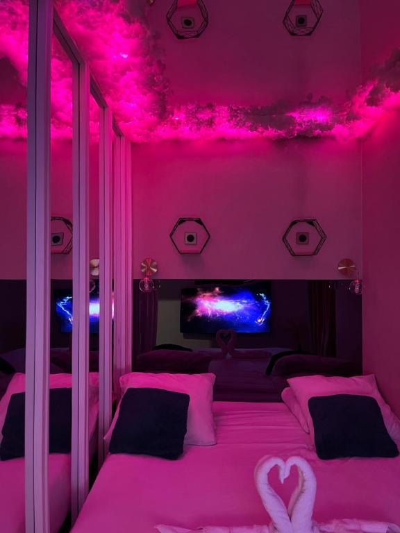 奥贝维利埃Le BLUE的粉红色的卧室,配有粉红色的灯床