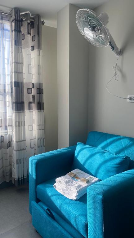 塔克纳Hotel Limani Suites的客厅配有蓝色沙发,设有风扇