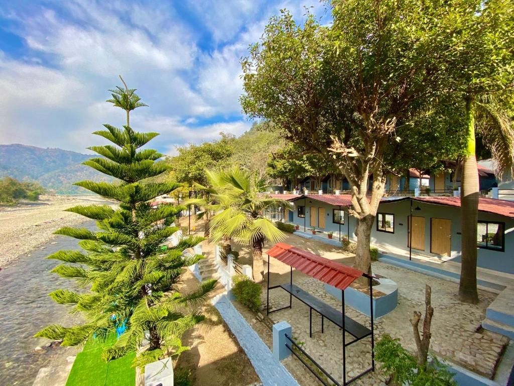 瑞诗凯诗Euphoric River Resort的享有带长凳和棕榈树的度假村景色