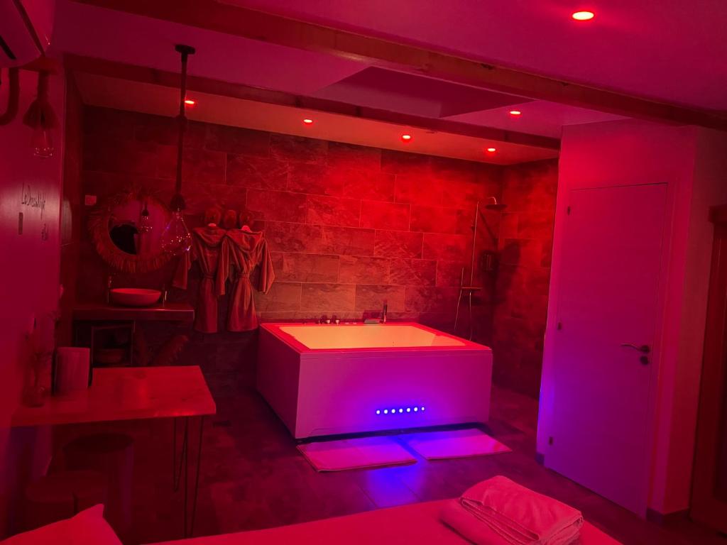 珀套特科姆博特La Dream Night的浴室设有白色浴缸和紫色灯