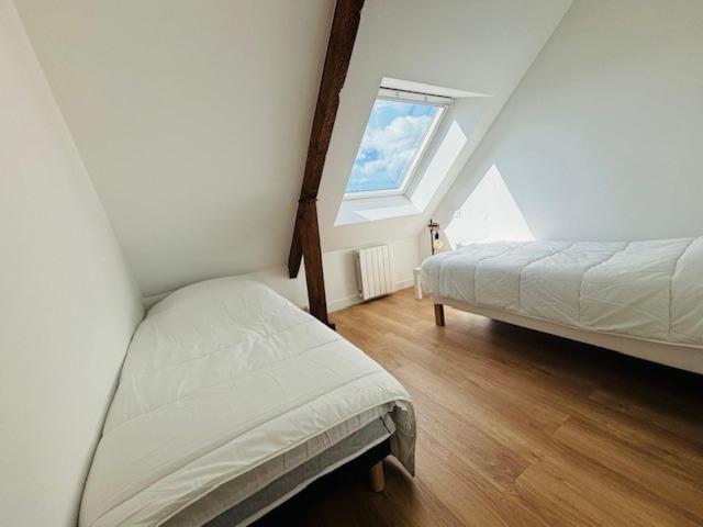 普洛埃默Les Chênes en duplex的阁楼卧室设有两张床和窗户。