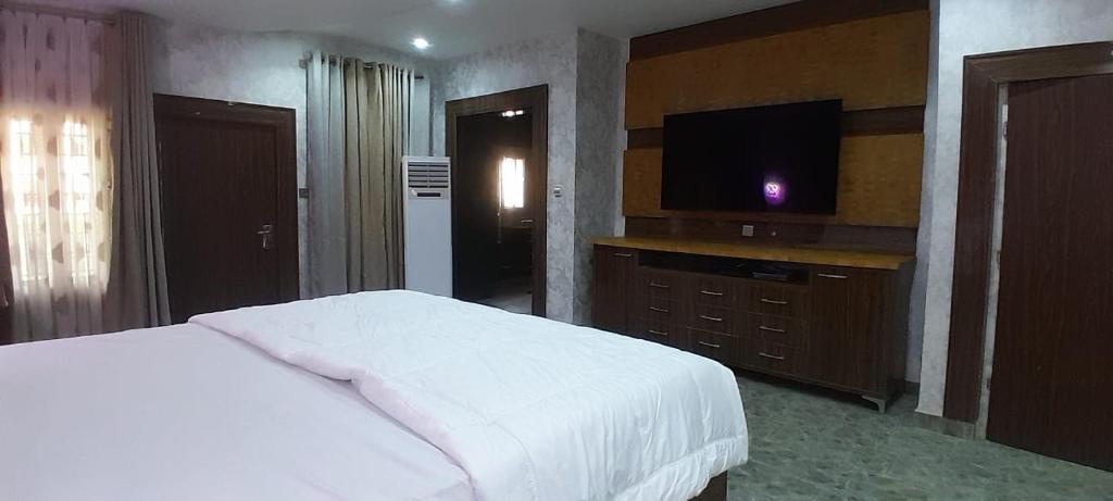 Tourista Travel and Tours的一间卧室配有一张床和一台平面电视