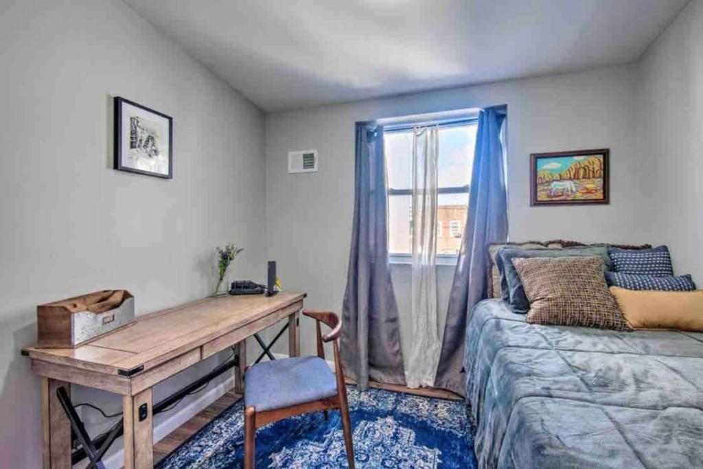 费城Modern South Philly Townhome的一间卧室配有书桌、床和窗户。