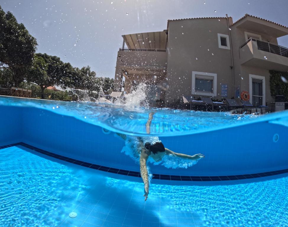 古瓦伊Four Seasons private villa - seaview - big heated pool - gym - sport activities的在游泳池游泳的人