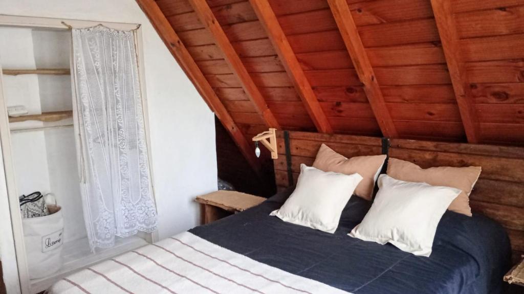 马德普拉塔Cabaña,Chalet Alpino Bosques de Peralta Ramos的一间卧室设有一张床和木制天花板