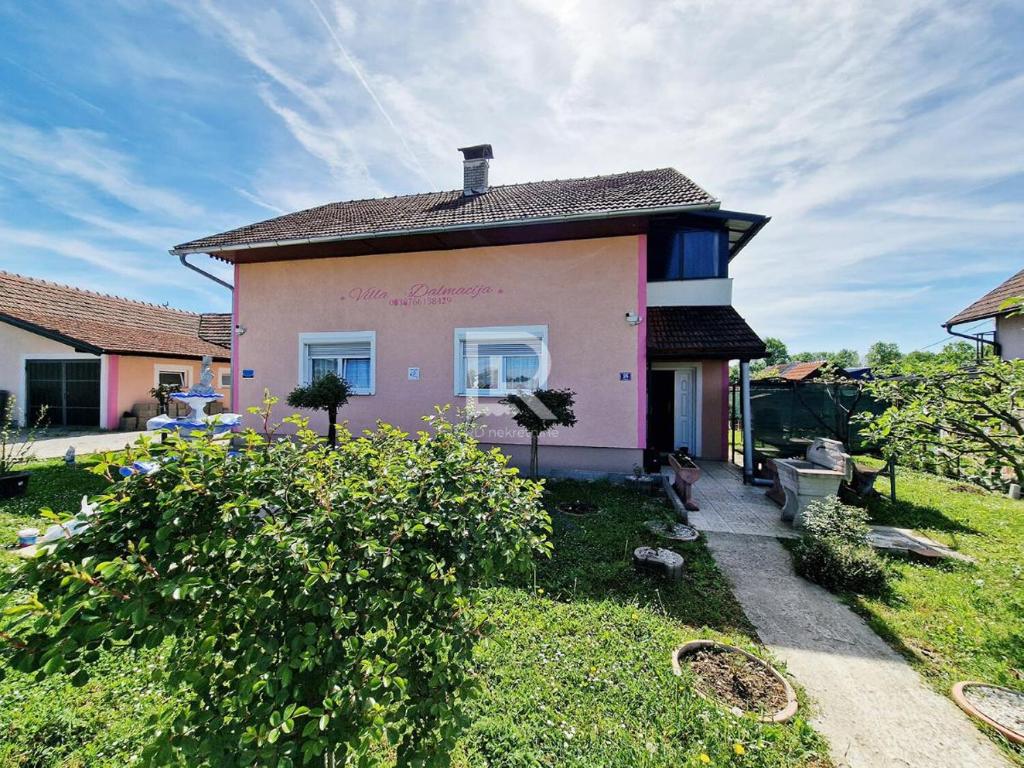 普里耶多尔Villa Dalmacija的一座带屋顶的粉红色小房子