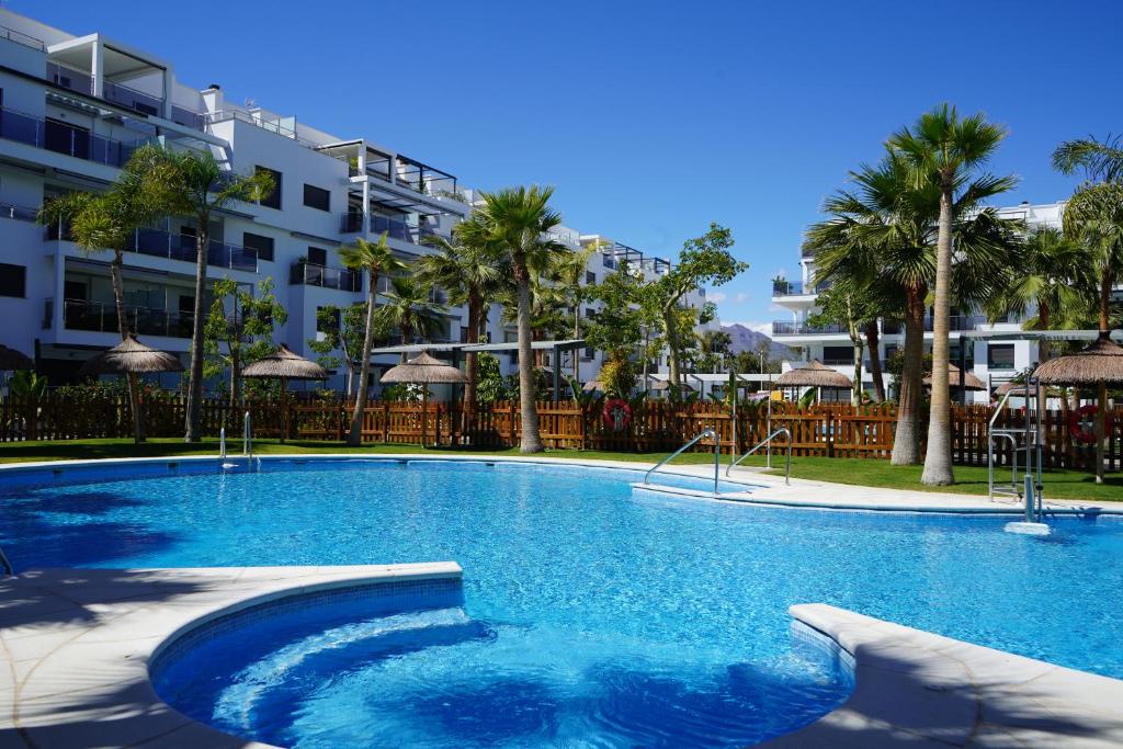 莫特里尔Aguacate Beach Apartamentos Playa Granada的大楼前的大型游泳池