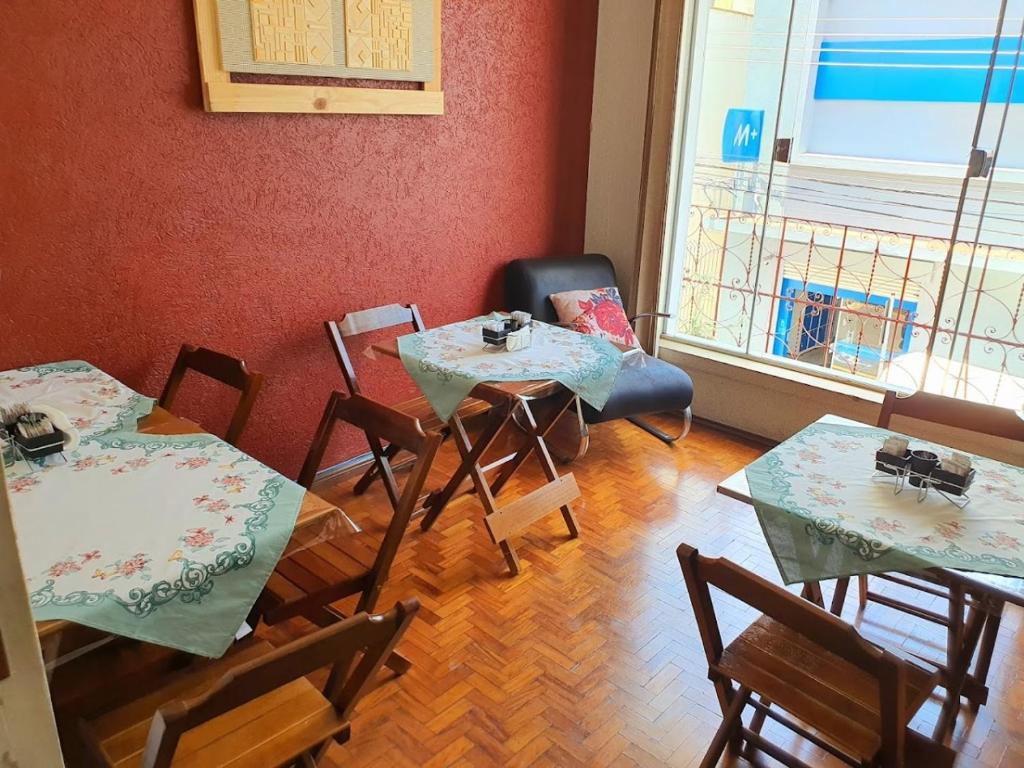 马里利亚CENTRALHE HOTEL的客房设有2张桌子和椅子以及窗户。
