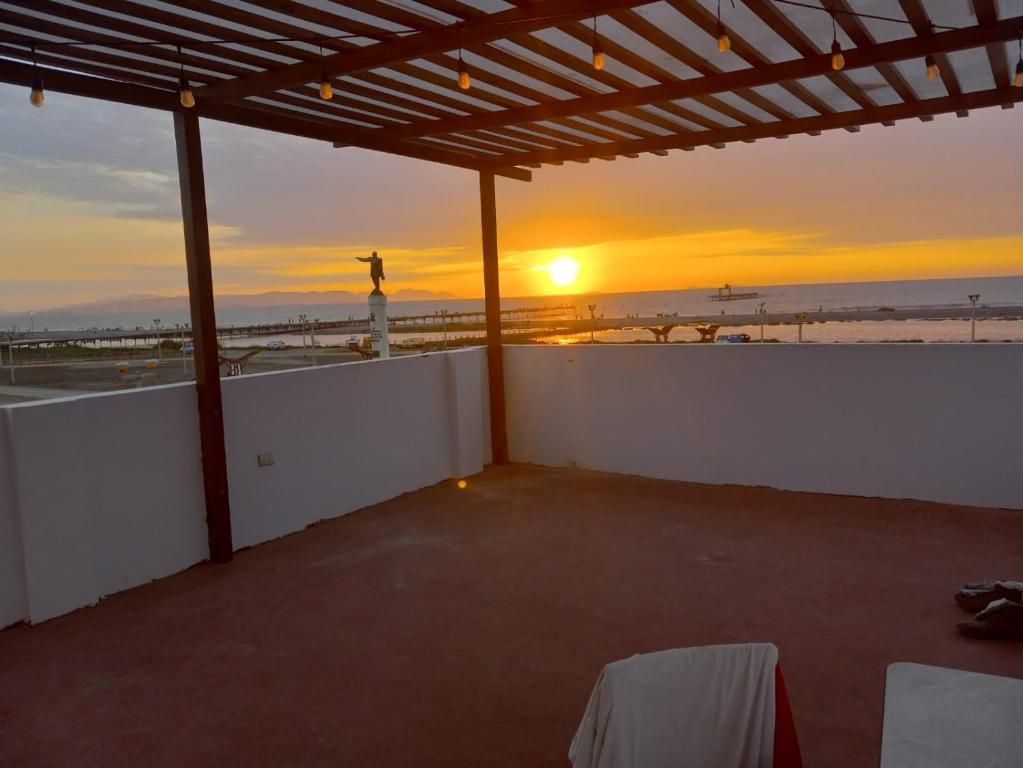 皮斯科Hospedaje Pariwana的露台享有日落美景,设有海滩