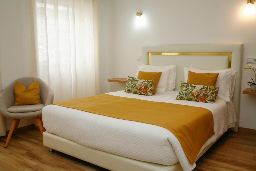 卡尔达斯达·赖尼亚Nova Delpa AL的一间卧室配有一张大床和一把椅子