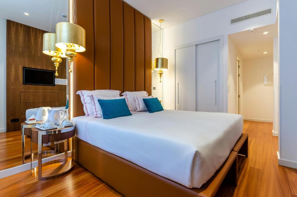 新德里Hotel Aurora Mirage Delhi的卧室配有带蓝色枕头的大型白色床