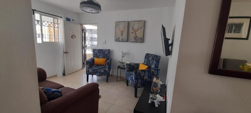 圣地亚哥洛斯卡巴Residencial Palmas De Gurabo的客厅配有沙发、椅子和桌子