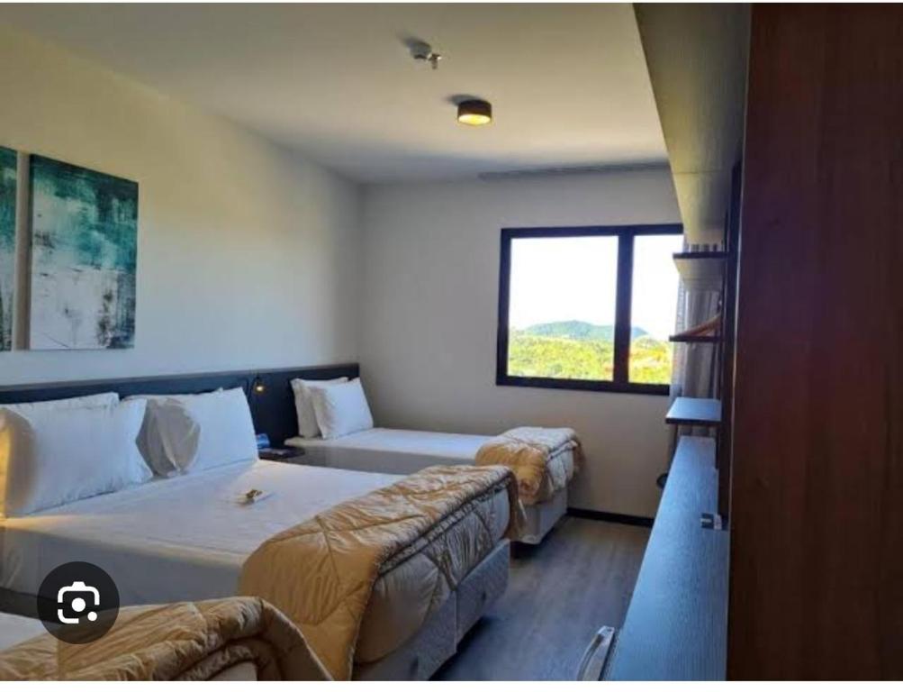 佩尼亚Hotel em frente ao Beto carreiro的一间卧室设有两张床、一张沙发和一个窗口