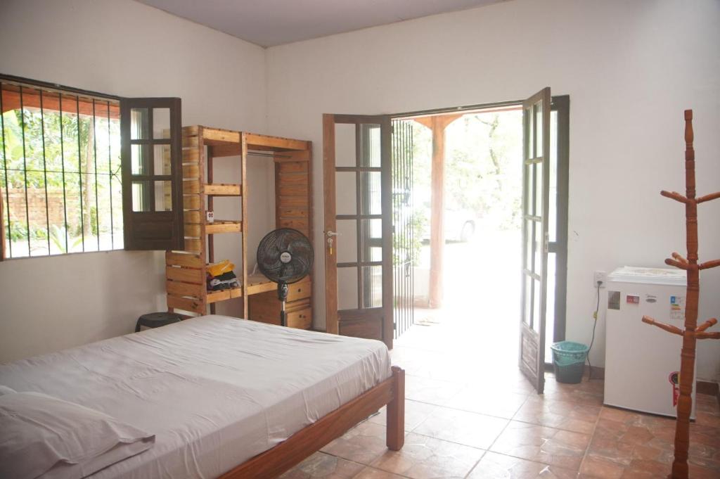 Sítio Peregrino das Estrelas的一间带一张床的卧室和一间带风扇的房间