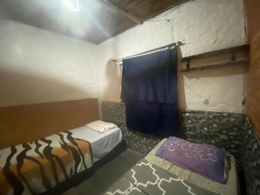 伊达贾伊Quarto com Vista do Rio的小房间设有两张床和窗帘