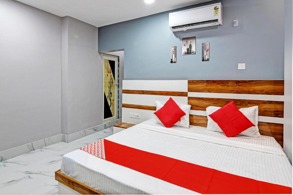 加尔各答OYO Tara Maa Guest House的一间卧室配有一张带红色枕头的大床