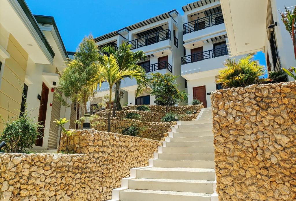 长滩岛RedDoorz @ LM Apartelle Boracay的通往棕榈树建筑的楼梯