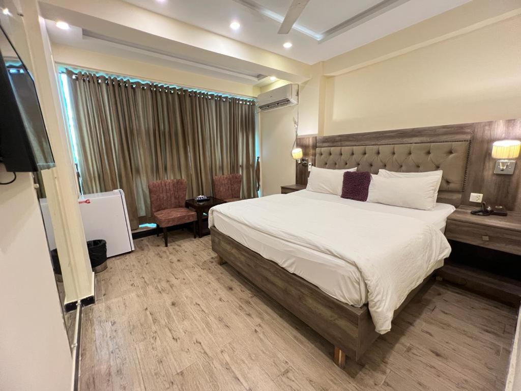 伊斯兰堡Islamabad Premium Hotel的酒店客房,配有床和电视