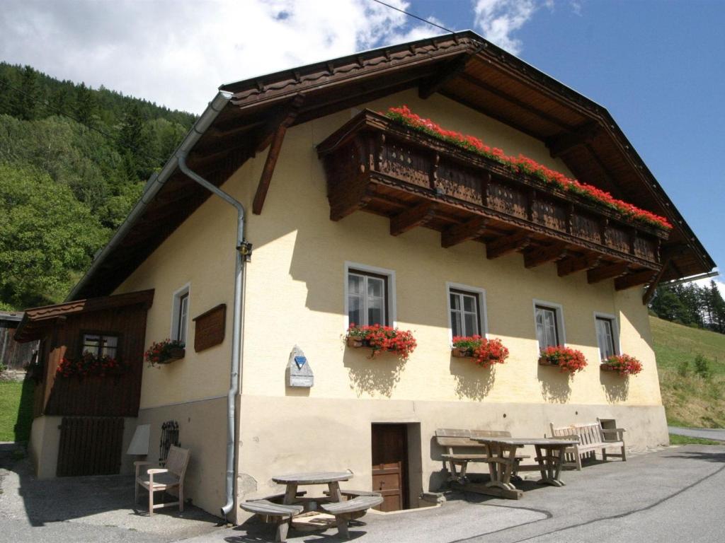上韦拉赫Holiday home in Obervellach near ski area的一座带野餐桌和阳台的建筑
