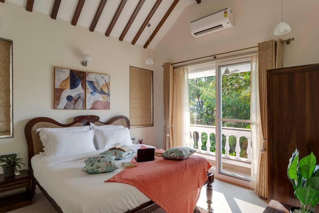 VerlaVilla Hestia-3bed villa in Assagao By Masaya Stays的一间卧室设有一张床和一个大窗户
