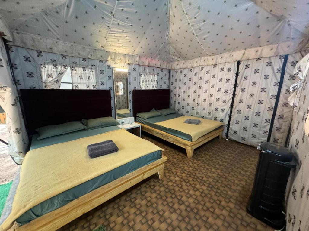马泰兰Nature Glamping的帐篷内带两张床的房间