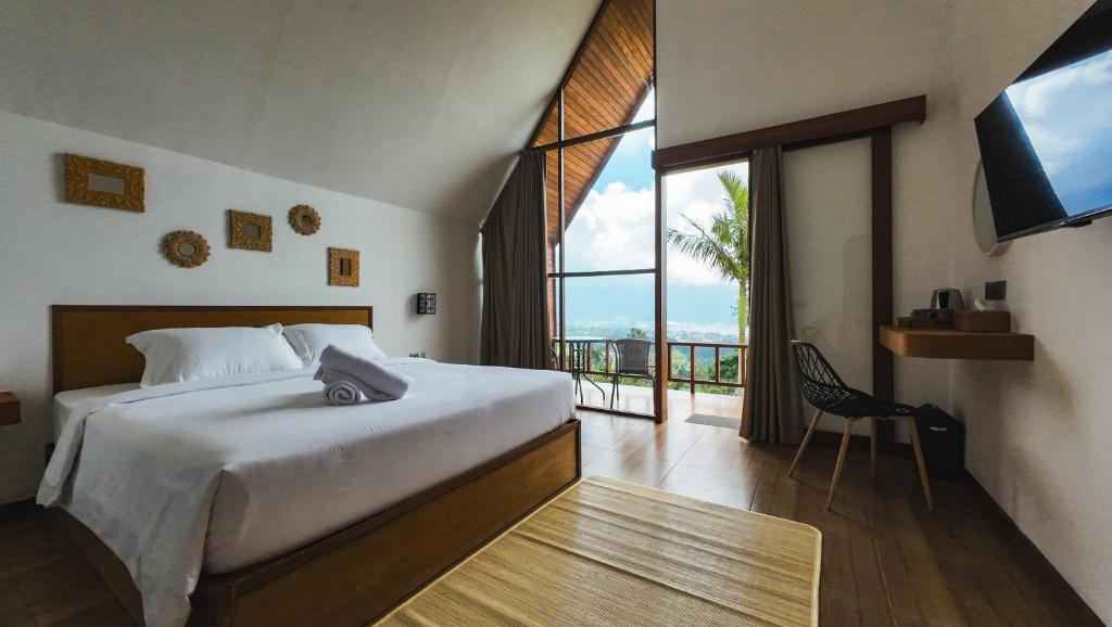 塔巴南Catu Glamping Bedugul的一间卧室设有一张床和一个大窗户