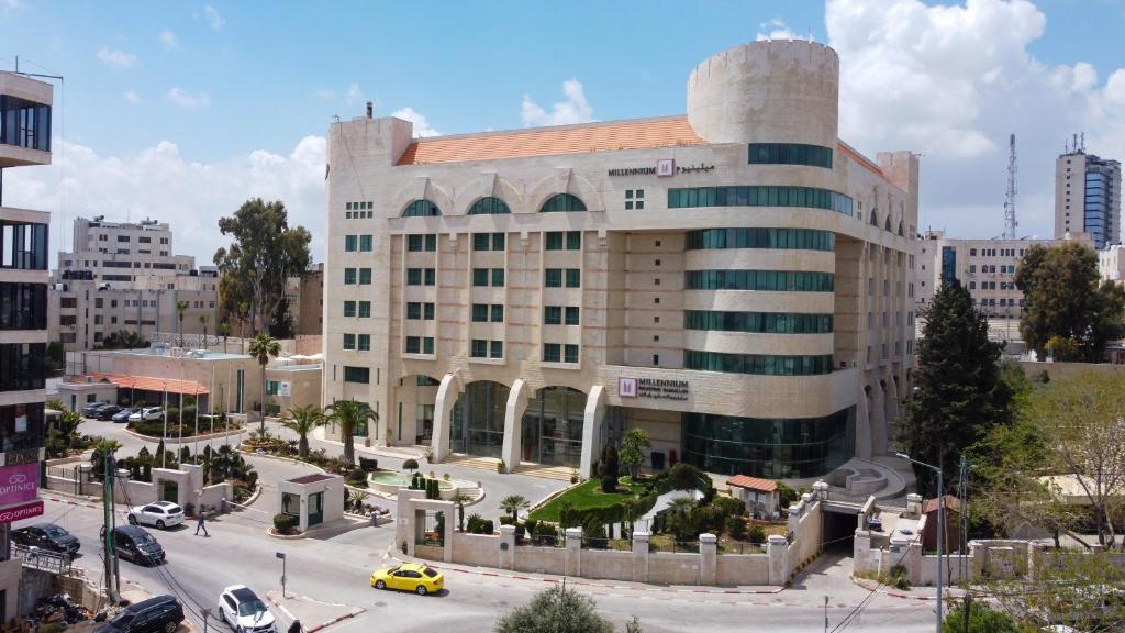 拉马拉巴勒斯坦拉姆安拉千年酒店的一座城市的大建筑,有停车场