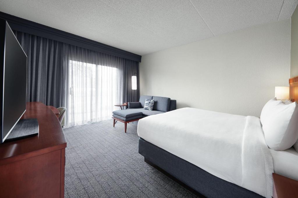 马里兰高地圣路易斯西港广场万怡酒店的酒店客房,配有床和电视