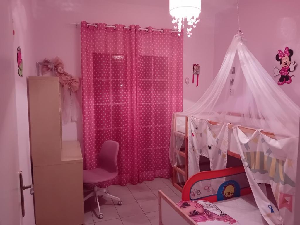 埃帕诺米Beautiful house的粉红色的房间,配有婴儿床和帐篷