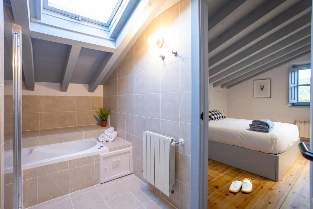 加利扎诺Casona Las Cinco Calderas的一间带浴缸的浴室和一张位于客房内的床