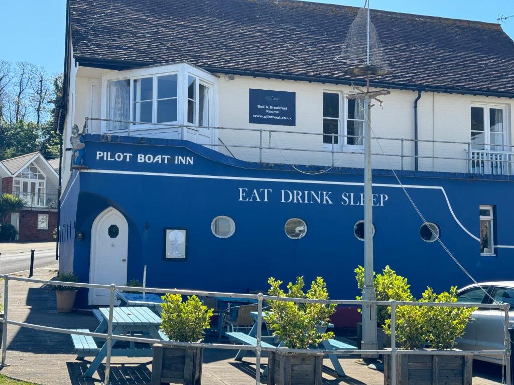 本布里奇The Pilot Boat Inn, Isle of Wight的停在房子前面的蓝色小船