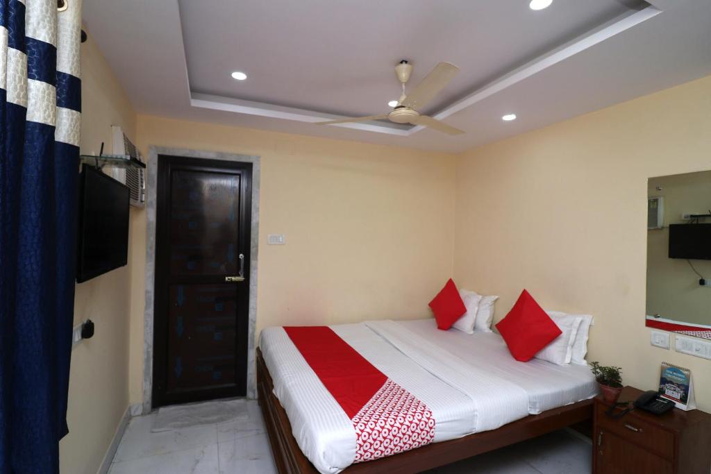 BumlitanOYO A G Residency & Son的一间卧室配有一张带红色枕头的床和天花板