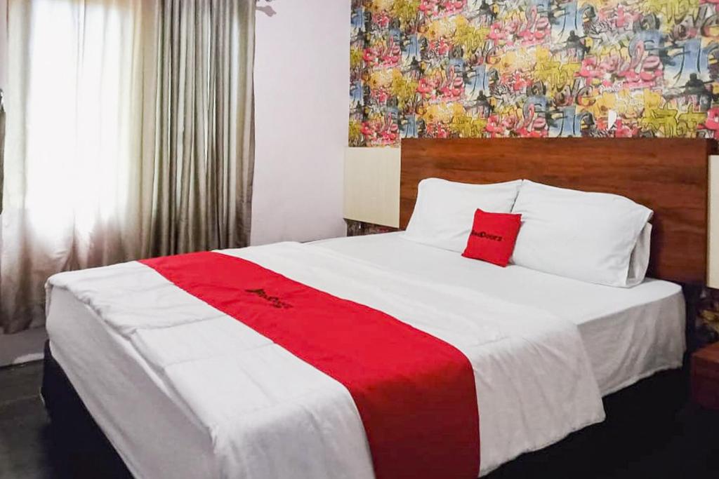 明古鲁省RedDoorz at Pantai Panjang Bengkulu 2的一间卧室配有一张大床,铺有红白毯子