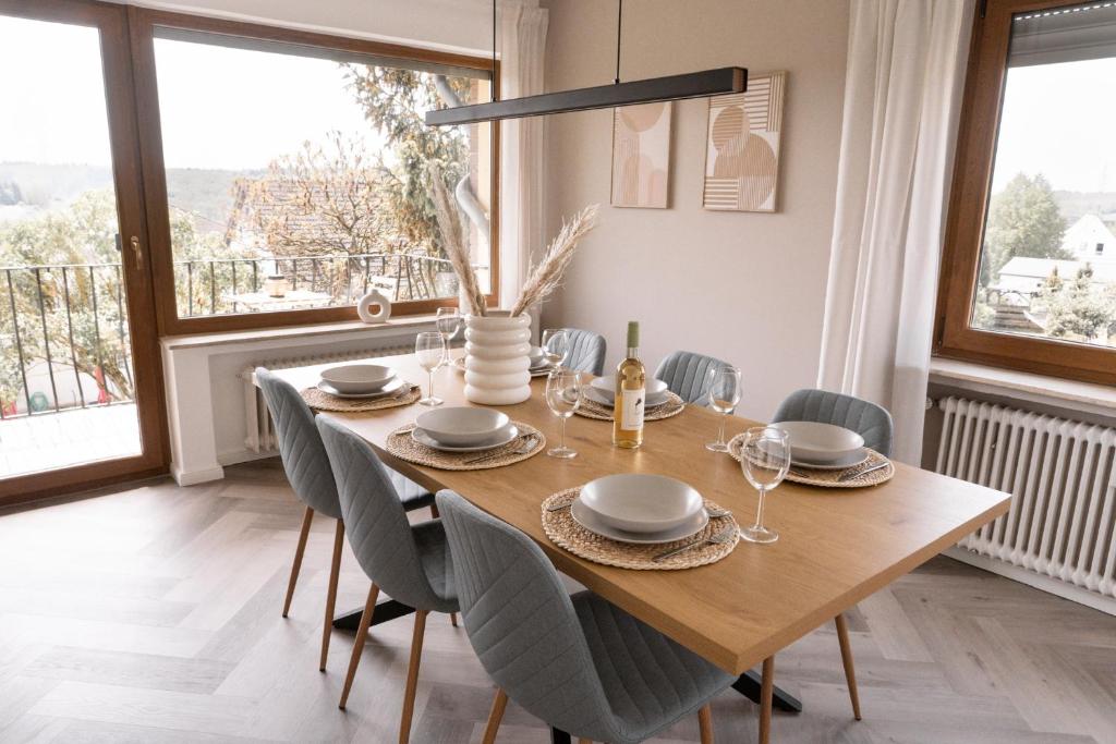TrierweilerTRIMOSA Apartments - cozy, modern und citynah的一间带木桌和椅子的用餐室